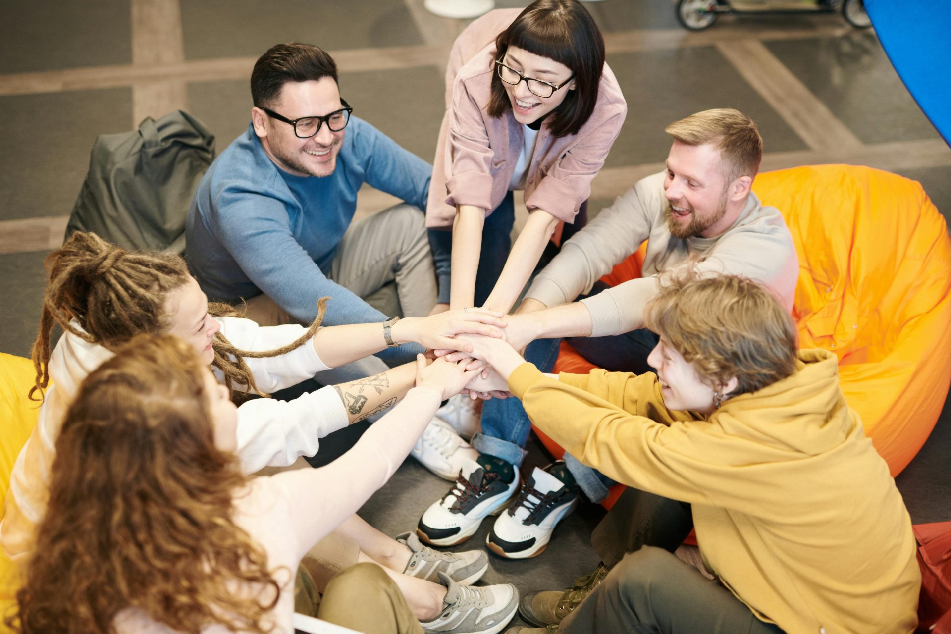 Group sitting in circle, hands stacked together