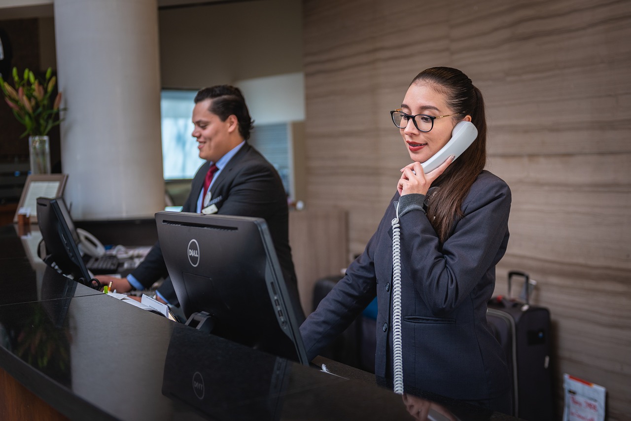 Receptionists working, answering phone at hotel desk